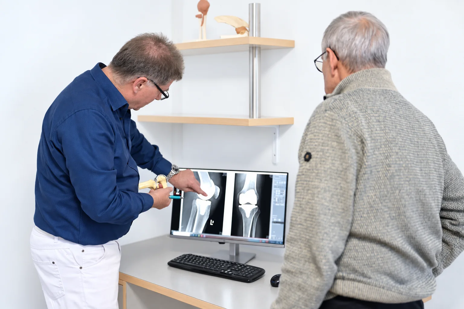 Dr. Meyer erklärt eine Knieaufnahme mit einem Gelenkmodell