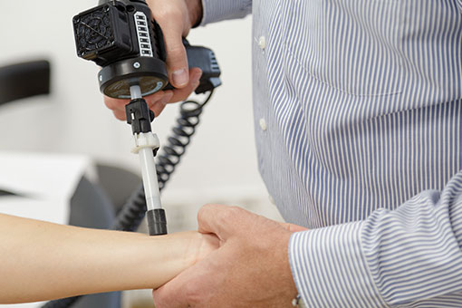 Medizinisches Handgerät wird an der Hand eines Patienten angewendet.