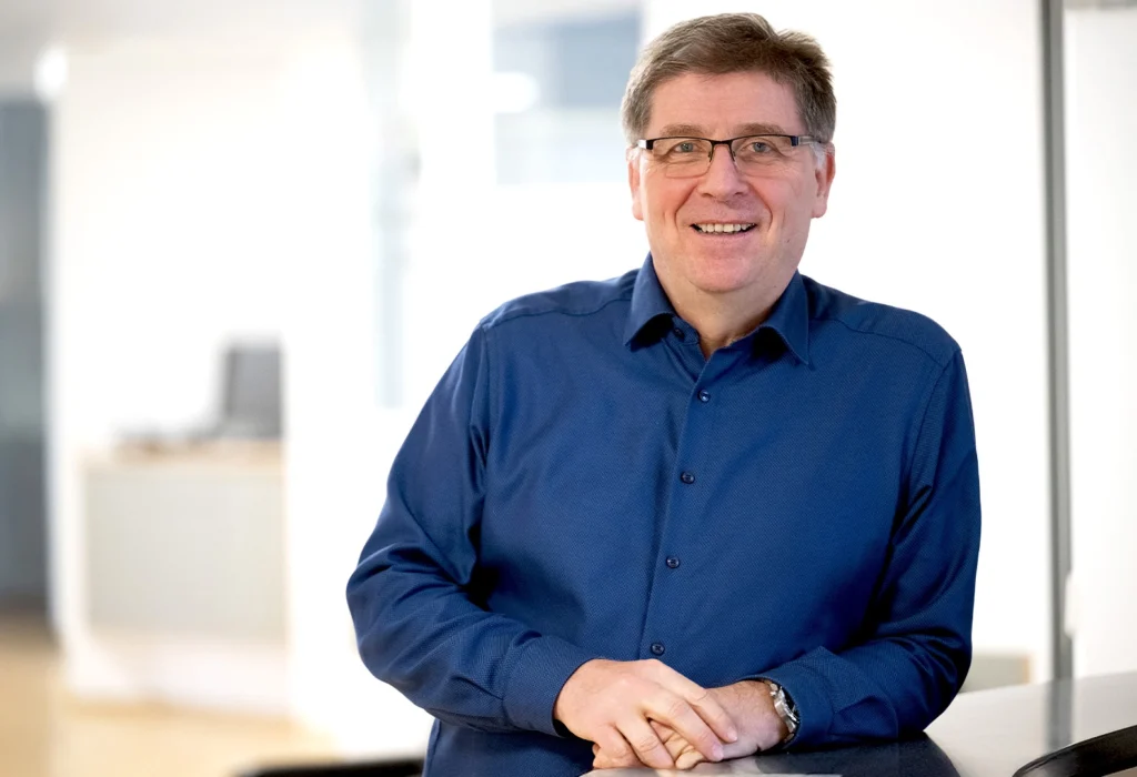Porträt eines lächelnden Arztes (Andreas Meyer) in einem blauen Hemd